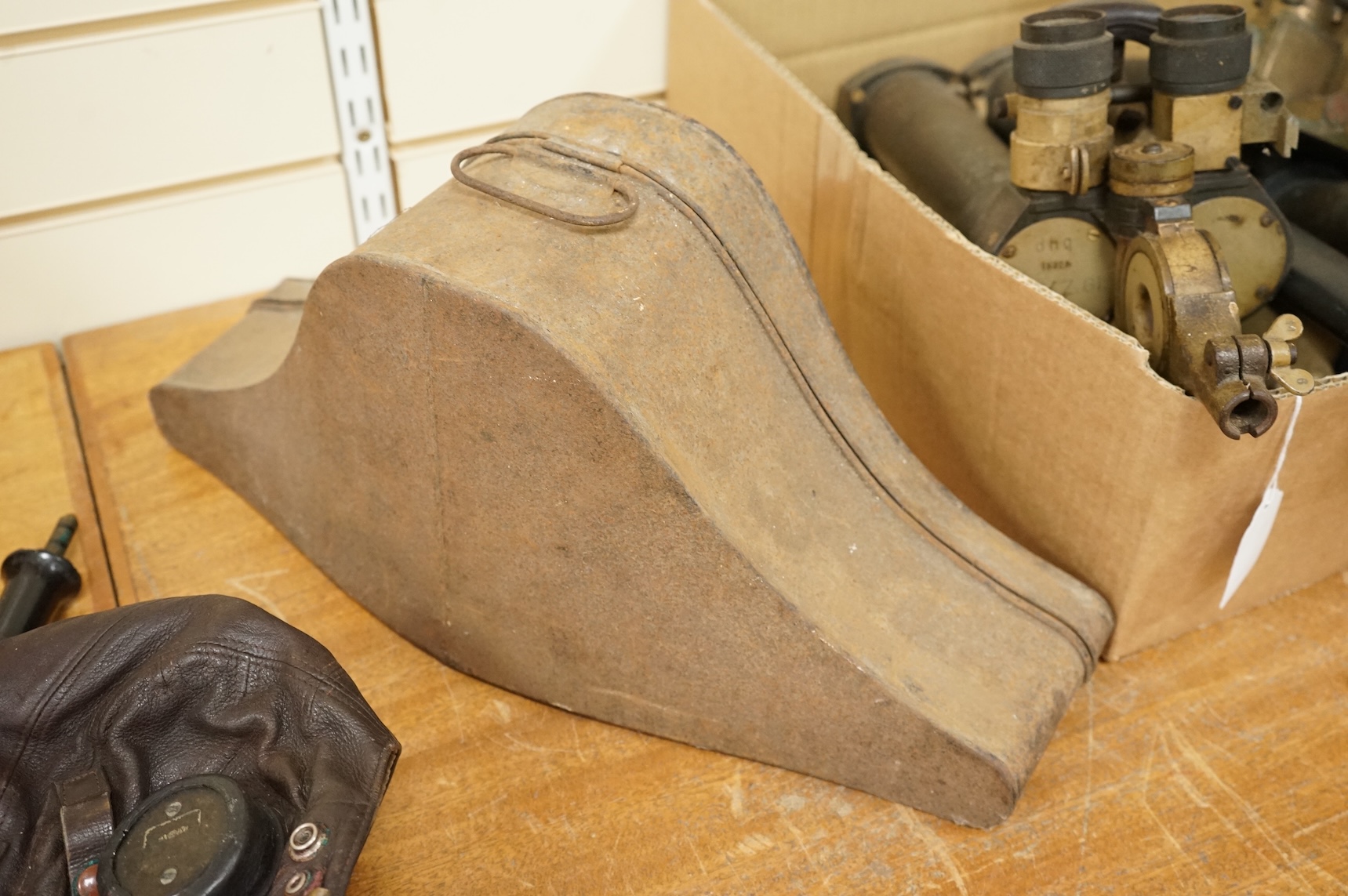A WWII RAF Air Ministry aviator’s leather head-gear, with built-in padded headphones, oxygen mask with microphone and other electrics incorporated into it, marked with a crown and ‘AM 10A/13466’ to one earpiece, together
